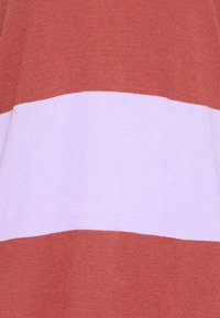 Medvilninis megztinis su horizontaliomis juostomis rūdžių raudonos ir švelnios rožinės spalvų, lygios tekstūros ir vidutinio storio.