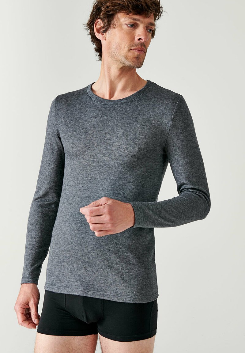 Langsleeve shirt in donkergrijs, gemaakt van een gladde stof, ronde hals, slimfit ontwerp, gecombineerd met zwarte shorts. Duidelijke en eenvoudige structuur.