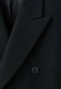 Schwarzer Wollmantel mit doppelreihigem Design, ausgeprägten Revers und einem einzigen schwarzen Knopf an der Vorderseite. Weiche Textur und klare Linien.