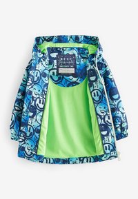 Färgglad jacka med en blå grafisk utsida prydd med leende ansikten. Insidan är ljusgrön med nätfoder och elastiska ärmslut.