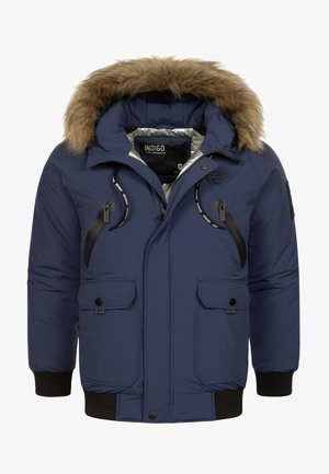 Tamno plavi jakni s kapuljačom obloženom krznom. Ima prednje džepove s zatvaračem i dugmima, rebraste manžete i sjajnu unutarnju oblogu.