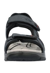 Svart sandaler med justerbara remmar och en vadderad innersula. Har en strukturerad fotbädd och en robust gummisula. Varumärkeslogotyp synlig.