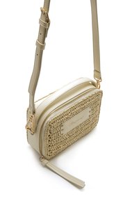 Bolso bandolera color crema con un frontal de tela tejida texturizada, laterales de cuero liso, herrajes dorados, cierre de cremallera y correa ajustable.