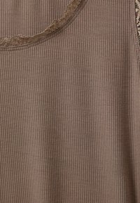 Barna bordázott ujjatlan felső kerek nyakkivágással és csipke díszítéssel az él�én. Az anyag sima textúrával rendelkezik, függőleges vonalakkal.