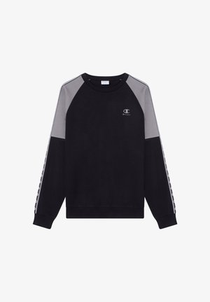 Zwarte trui met grijze raglanmouwen, ribgebreide manchetten en tailleband. Heeft een klein logo op de borst en patroon details langs de mouwen.