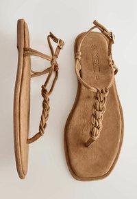 Hnedé semišové sandále s plochou podrážkou, opletenými remienkami a prackami na členkoch, zobrazené zhora a z boku na neutrálnom pozadí.