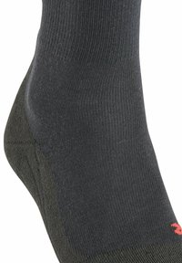 Ciemnoszara skarpetka z prążkowaną teksturą, wzmocnionym piętą i kontrastowym czerwonym logo na kostce. Materiał wydaje się elastyczny i gładki.