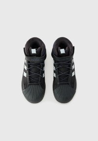 Tenis de cano alto pretos com uma biqueira de borracha texturizada, gola almofadada e atacadores azuis. Apresenta três riscas brancas laterais e um logotipo bordado.