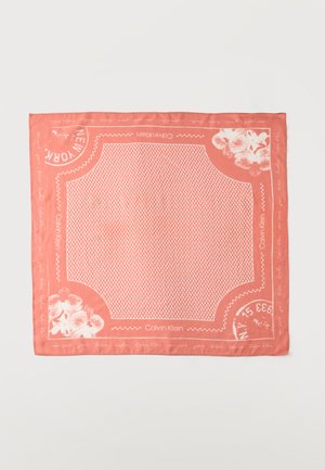 Sciarpa quadrata color corallo rosa con accenti floreali bianchi, motivo geometrico al centro, scritta "Calvin Klein" e nomi di città lungo il bordo.