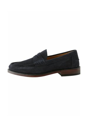 Mocassins en suède bleu marine avec un bout arrondi, des détails cousus sur le dessus et un talon en bois plat. Design minimaliste sans accents matériels.