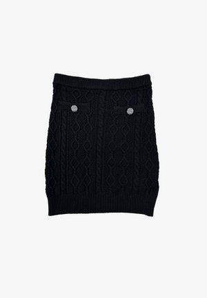 Gonna nera a maglia con motivo a trecce, vita a coste e due tasche decorative frontali con bottoni metallici.
