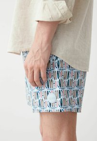 Shorts da nuoto in azzurro chiaro con motivo di tavole da surf in varie colorazioni. Patch del logo Colmar bianco sulla gamba inferiore. Tessuto leggero e texturizzato.
