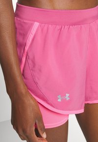 Rosa sportshorts i lättviktsmaterial med ett nätpanel, med en slät textur och en silverlogotyp på sidan.