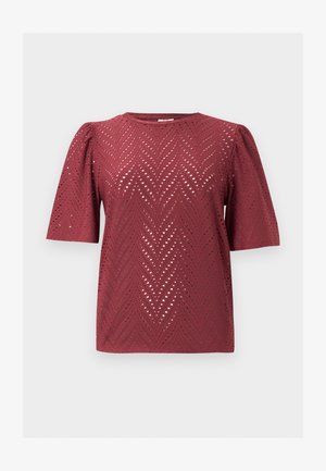 Blouse bordeaux à manches courtes avec motif découpé en chevron et épaules légèrement bouffantes, posée à plat sur un fond uni.