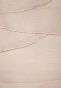 Tessuto beige chiaro con una texture stratificata e fluente; i bordi cuciti, l'aspetto liscio e la lucentezza sottile creano un look delicato.