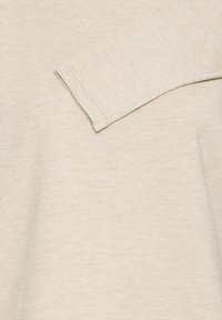 Hellbeiger, gestrickter Pullover mit geripptem Muster und langen Ärmeln, mit rundem Ausschnitt und klaren, minimalistischen Nahtdetails.