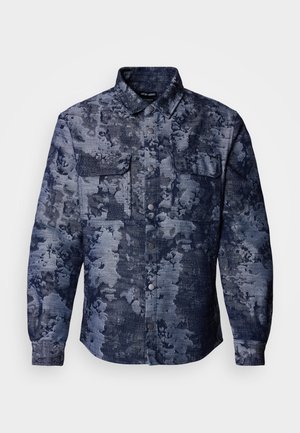 Denim shirt featuring a dark blue floral pattern, two chest pockets, button-up front, and a classic collar design. Textured fabric.