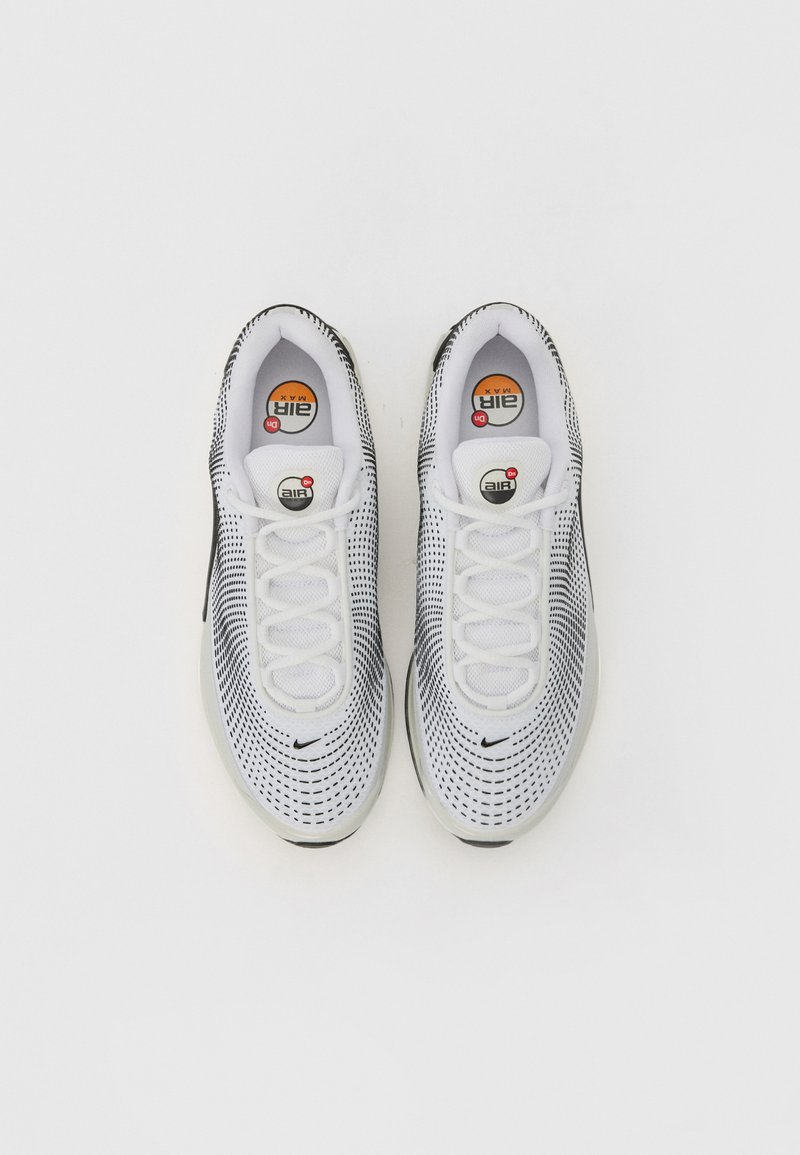 Baskets blanches et noires avec un dessus en mesh perforé, bout rond, lacets et affichage de la marque Air Max visible sur la languette et la semelle.