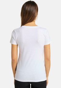 Hvid t-shirt med korte ærmer og rund halsudskæring, lavet af blødt bomuldsstof, med et enkelt, udekoreret design og en afslappet pasform.