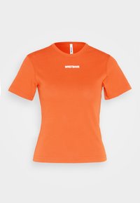 Oranžové bavlněné tričko s krátkými rukávy, kulatým výstřihem a bílým textem "WRSTBVR" potisknutým na přední straně. Hladká textura, standardní střih.