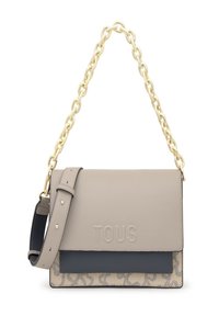 Bolso de hombro de piel beige y marino con asa de cadena dorada, correa ajustable y logo TOUS embossado en la tapa delantera.