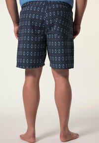 Costumi da bagno blu e neri con un disegno a diamante, cintura elastica, lunghezza sopra il ginocchio e una texture di tessuto leggero.