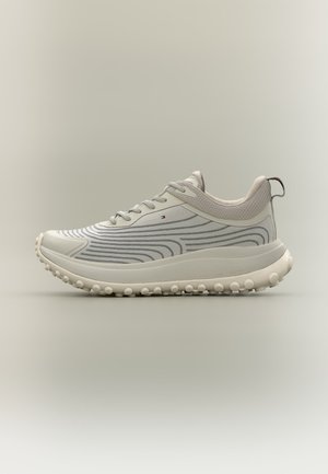 Lysebeige atletiksneakers med grå bølgede striber, tekstureret sål med runde greb og trækstrop på hælen.