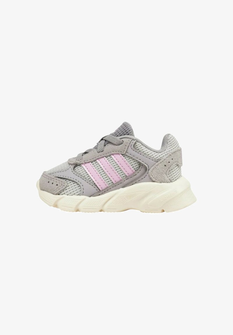Scarpa sportiva grigia realizzata in materiali a rete e suede, con strisce rosa, suola testurizzata e colletto imbottito. Design leggero con chiusura a lacci.