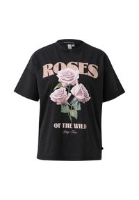 Czarna bawełniana koszulka z nadrukiem różowych róż i tekstem "ROSES OF THE WILD, Stay True" w stylizowanej, postarzanej czcionce. Krótkie rękawy.