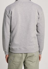 Felpa grigia con polsini e orlo a coste, realizzata in materiale morbido, con vestibilità classica e senza loghi o motivi visibili. Vista posteriore mostrata.