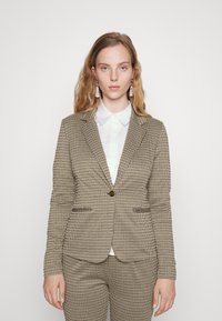 Blazer in een geruit patroon, in beige en zwarte tinten, met een enkele knop, reverskraag en een getailleerde pasvorm met twee voorzakken.