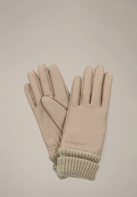 Skórzane rękawiczki w jasnym beżu z prążkowym ściągaczem w delikatnym beżu. Posiadają dopasowany krój i bezszwowe palce. Dyskretne logo na nadgarstku.