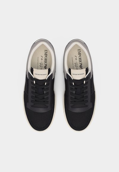 Ζευγάρι από μαύρα και μπεζ αθλητικά παπούτσια Emporio Armani με λεπτομέρειες από δίχτυ, σχεδιασμό με κορδόνια και επενδύσεις με λογότυπο, απεικονισμένα από πάνω προς τα κάτω.