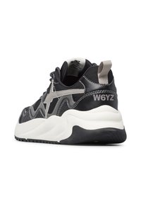 Sneaker nera e grigia con una tomaia texturizzata, linee di design ondulate e una spessa suola bianca. Presenta un occhiello sul tallone e un dettaglio con il logo.
