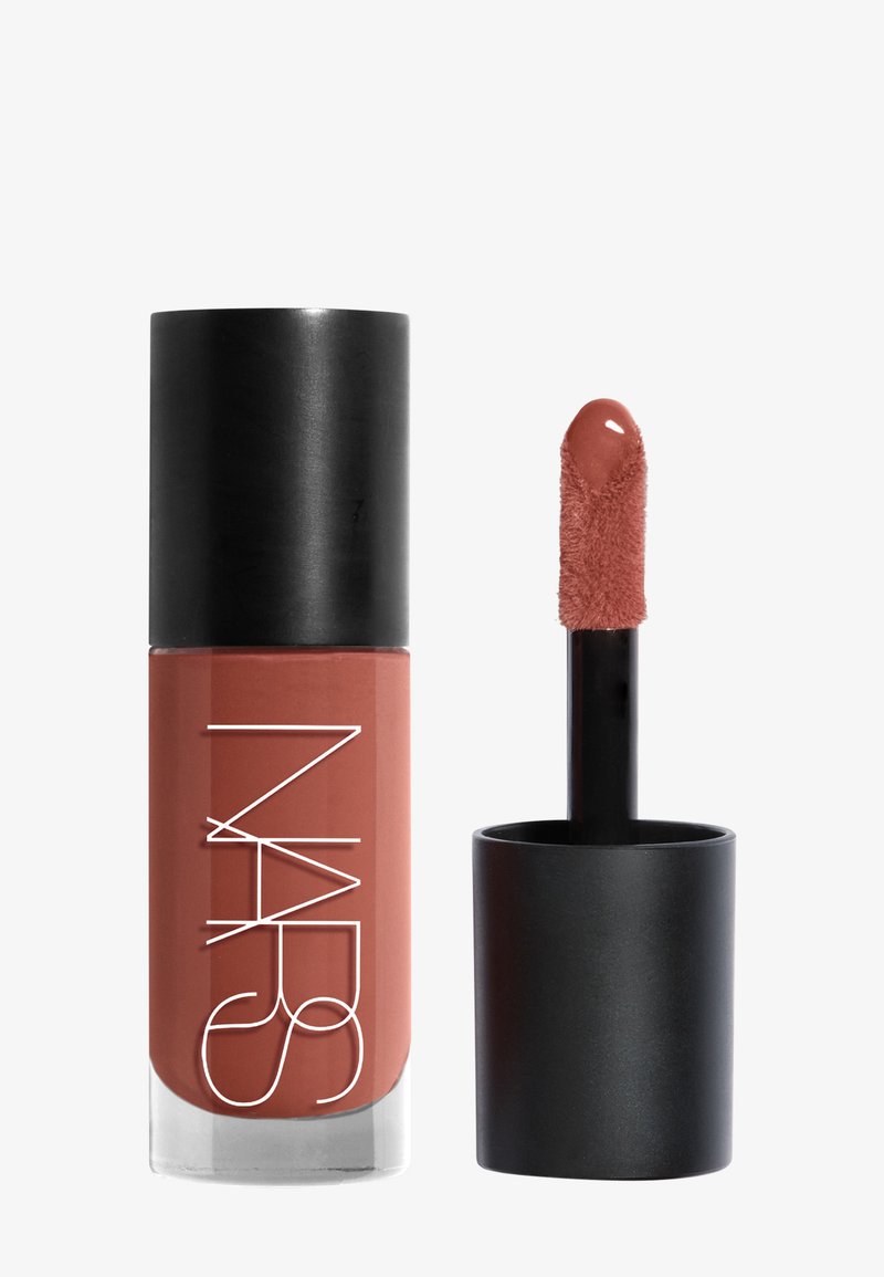Rouge à lèvres liquide NARS avec un capuchon noir à côté d'une baguette applicatrice enduite d'un gloss à lèvres couleur rose doux.
