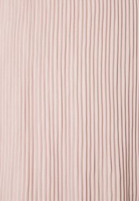 Tela texturizada en rosa suave, con pliegues verticales. Superficie lisa con un brillo sutil, creando un efecto de capas.