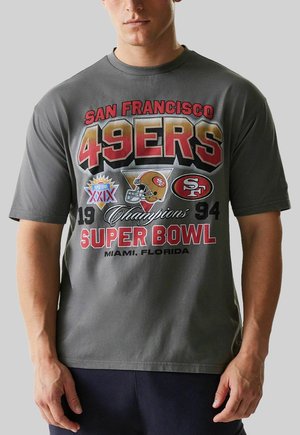 Graues T-Shirt mit kurzen Ärmeln, das auffällige rote und gelbe Grafiken zeigt, darunter "49ERS", Super Bowl-Logos und den Text "Miami, Florida". Aus Baumwollmaterial.