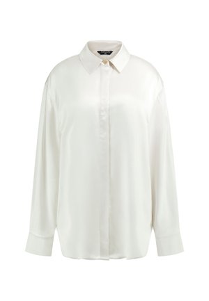 Weiße Bluse mit langen Ärmeln, Knopfleiste, spitzem Kragen, einem sichtbaren oberen Knopf und weiter Passform vor schlichtem Hintergrund.