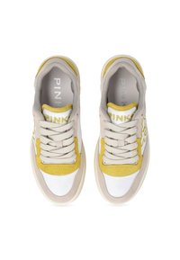 Beige and yellow sneakers with a textured fabric upper, white toe cap, and tonal laces. Features embroidered branding and a cushioned sole.