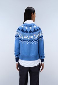 Maglione blu lavorato a maglia con accenti decorativi in blu scuro, bianco e crema, caratterizzato da un collo rotondo e polsini e orlo a coste.