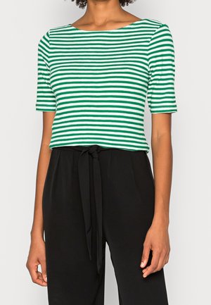 Zielono-biały paskowany top z krótkim rękawem i dekoltem typu łódka, wykonany z miękkiego materiału. Połączony z czarnymi spodniami o wysokim stanie z kokardą.