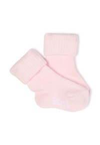 Chaussettes en coton rose clair avec un revers côtelé et une texture lisse. Présente un logo blanc sur la semelle.