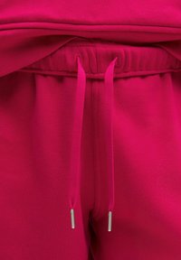 Fuchsia joggers med elastisk midja, med snörning och metallaglets. Mjuk, slät tyg med minimal textur.