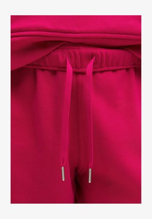 Fuksijaste hlače z elastičnim pasom, ki imajo vrvico in kovinske konice. Mehka, gladka tkanina z minimalno teksturo.