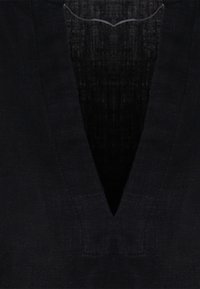 Top in lino scuro con scollatura a V profonda e tessuto testurizzato. Il design presenta una finitura liscia e sottile con linee pulite.