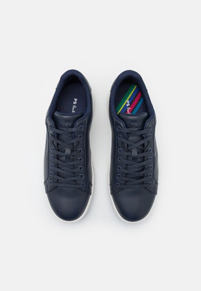 Mörkblå lädersneakers med snörningsdesign, vita gummisålar och färgglada randiga inlägg. Slät textur och rundad form.