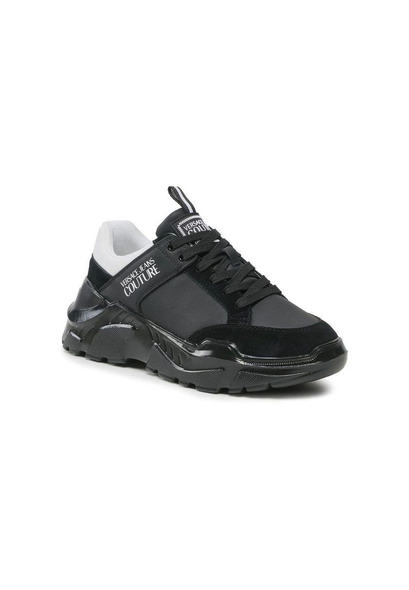 Schwarzer Sneaker mit einer Mischung aus Texturen, darunter glattes Leder und Wildleder, mit einer weißen und schwarzen Ferse, dicker Sohle und markierten Akzenten.