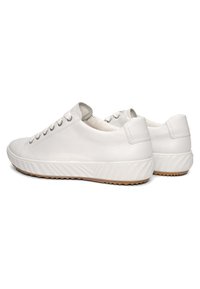 Baskets basses en cuir blanc avec des lacets blancs, des semelles en caoutchouc texturées et une semelle extérieure marron à rainures, vues sous un angle arrière latéral.