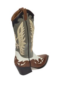Bota de vaquero con punta afilada, de cuero marrón, blanco y gris, y con un intrincado bordado en color beige con patrones en forma de alas a lo largo del caña.