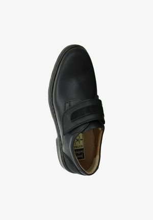 Zapato de cuero negro con punta redondeada, correa ajustable de velcro y plantilla texturizada. Presenta una suela de goma y un diseño minimalista.